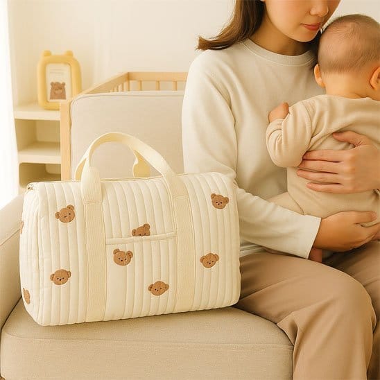 Maman asise et bébé contre elle avec Sac a langer bebe beige avec motifs ourson