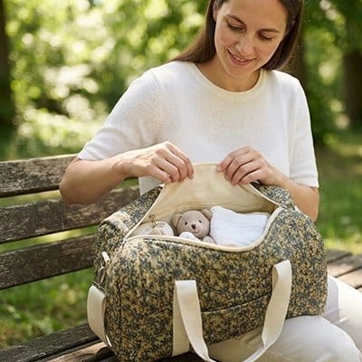Maman sur un banc de parc avec Sac a langer