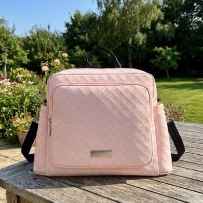 Sac à dos à langer rose pastel sur Table de parc