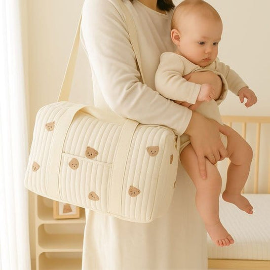 Sac a langer bebe beige avec motifs ourson a l'épaule de maman avec bébé dans les bras